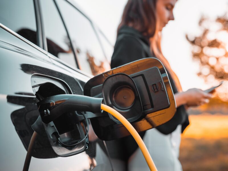 Young,Woman,Browsing,On,A,Smartphone,While,Waiting,To,Charge